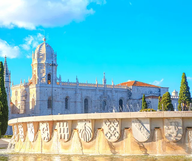 Jeronimos Monastery exterior in the background with a fountain in the park in the foreground