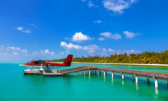 a seaplane parked by a dock in the maldives