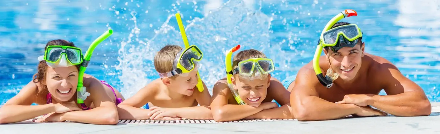 A family of four sat by the pool with snorkels on